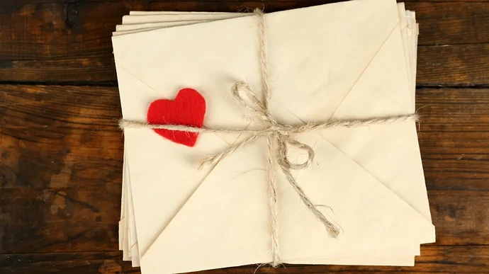 stack-of-love-letters-on-rustic-wooden-planks-background