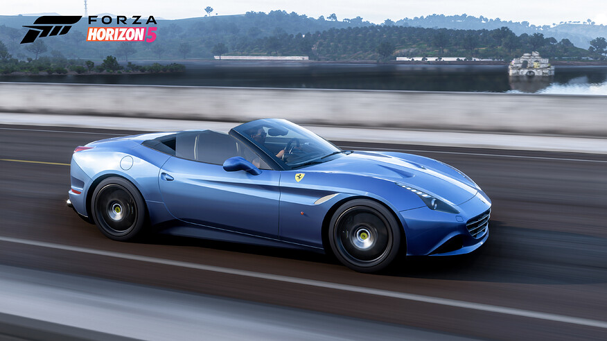 A blue Ferrari California T driving with the top down