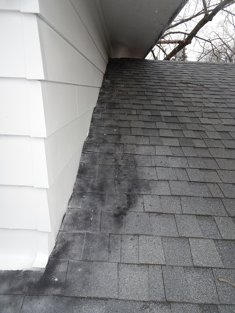 Dark stains on shingles along headwall and sidewalls Roofing