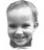 The image is a blurry, low-resolution photograph of a young child's face, with the child looking directly at the camera and smiling. (Captioned by AI)